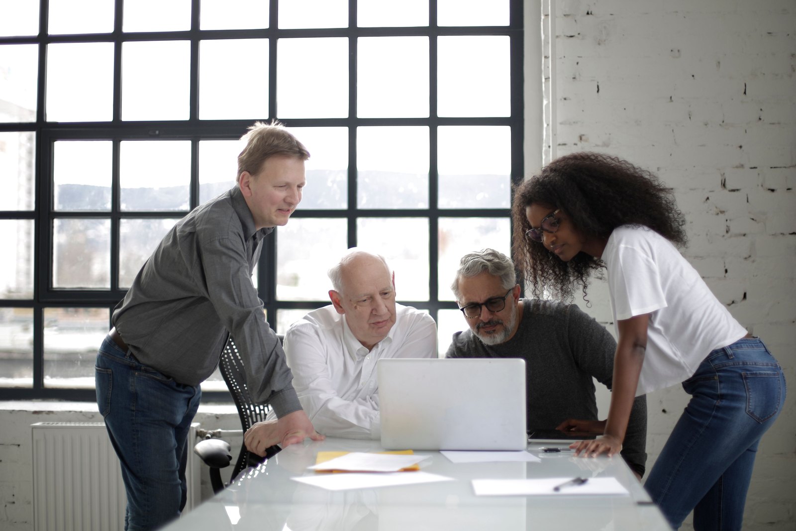 Security architecture review: engineers collaborating around one screen Colleagues collaborating around a laptop in a bright workspace